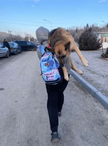 أوكرانية تحمل كلبها 